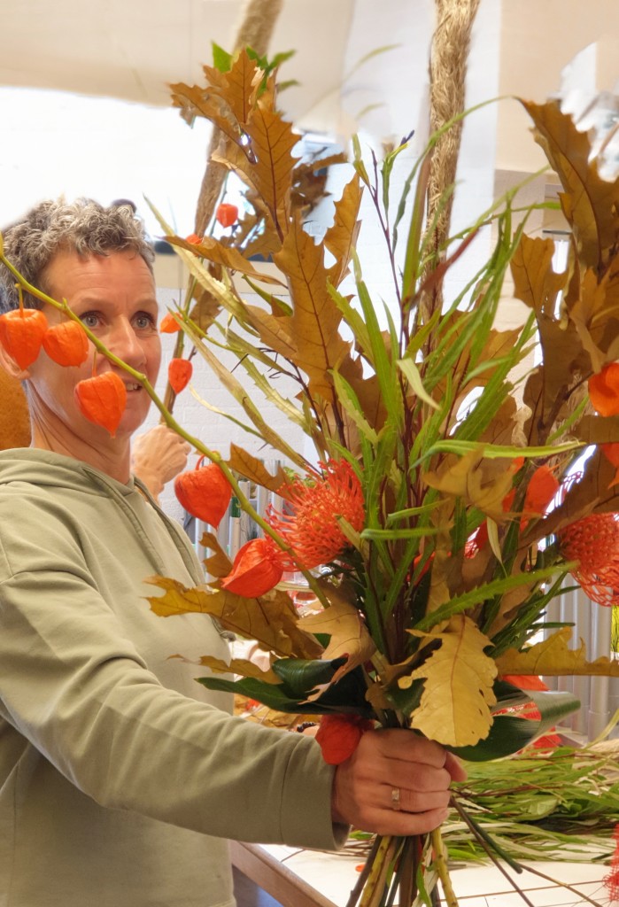 Nathalie, cursiste van After All Vakopleidingen Bloemschikken, is bijna klaar met haar Handgebonden Boeket.