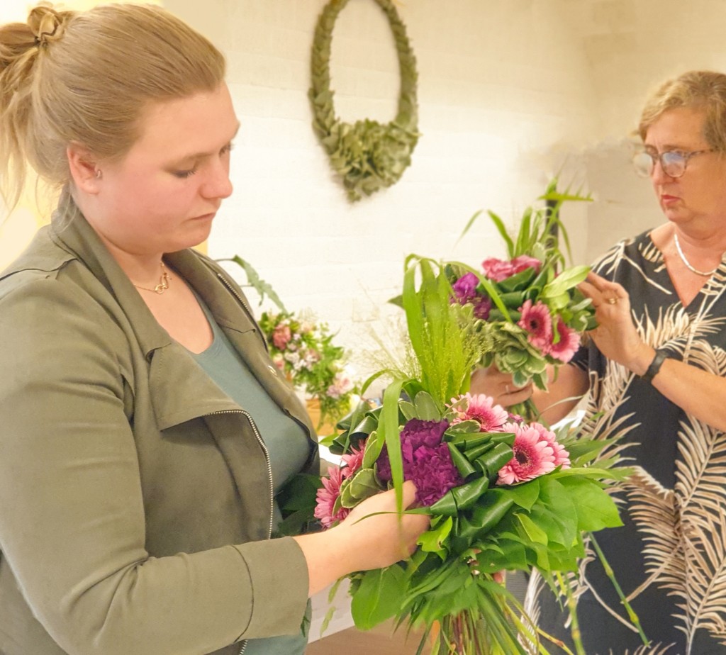 Linda en Bernadette, cursisten van After All Vakopleidingen Bloemschikken, leggen de laatste hand aan hun Bruidsboeketten.